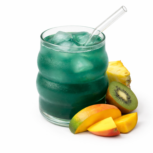Green iced drink in a glass with fruit on a white background