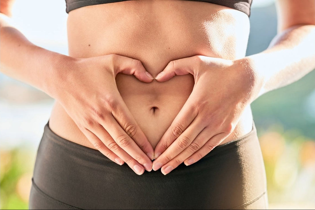 Hands forming a heart over the lower abdomen to represent gut health, digestion, and supportive wellness practices.