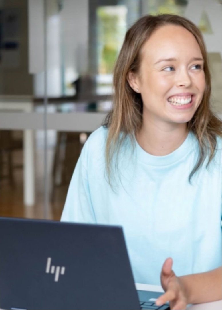 Woman using an HP laptop in a modern indoor setting
