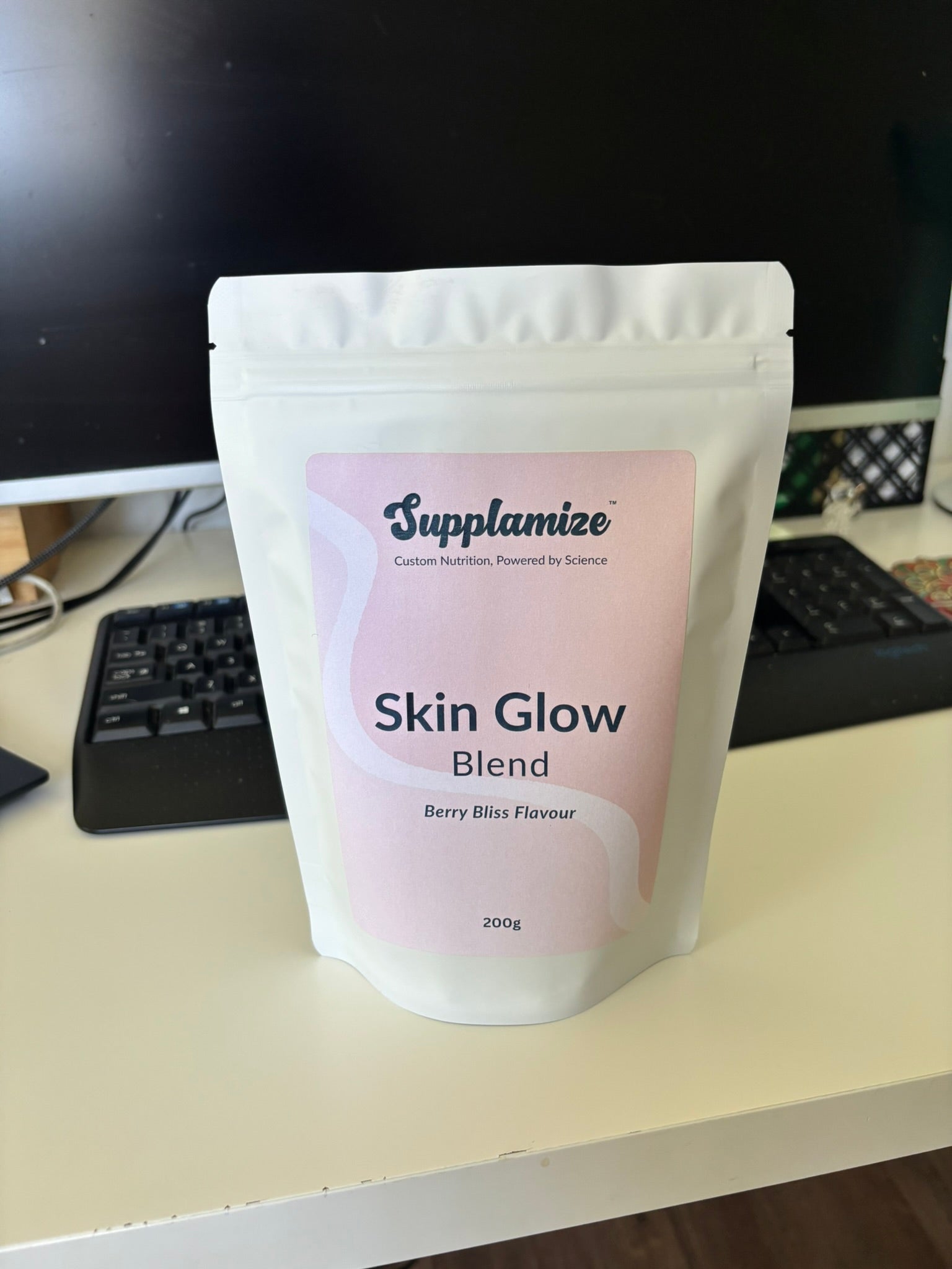 Supplamize Skin Glow Blend package on a desk with a computer monitor in the background