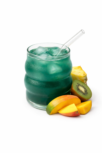 Green iced drink in a glass with fruit on a white background